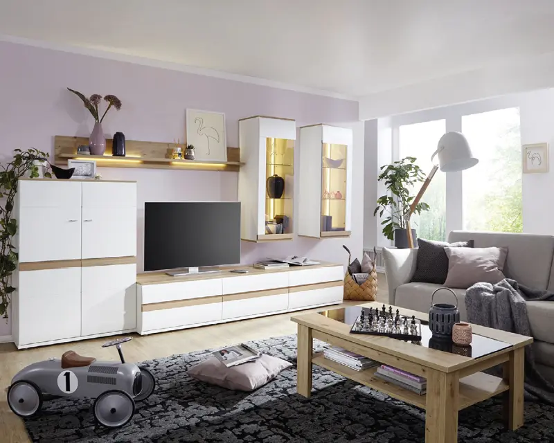 Wohnzimmer mit weißer Wohnwand, TV, Couchtisch, grauem Sofa und schwarzem Teppich